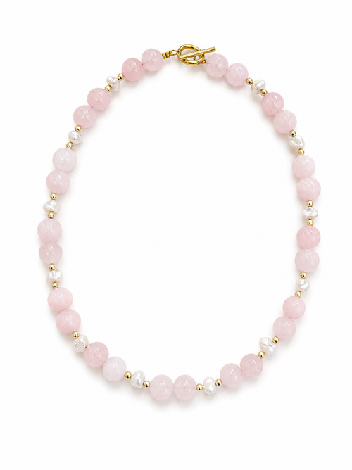 Pink beaded bracelet with gold accents on a white background