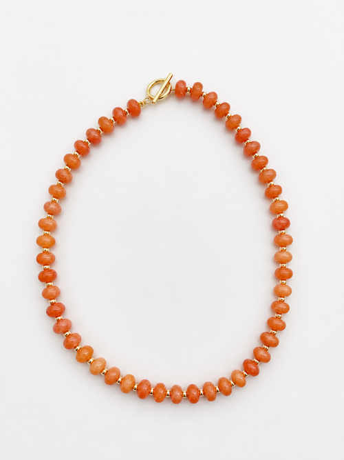 Necklace with orange beads on a white background