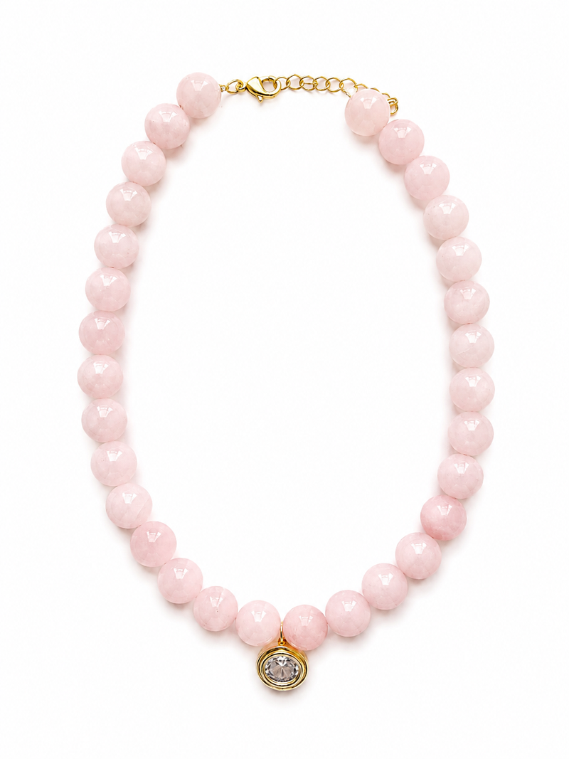 A pink faceted bead necklace with a gold-tone clasp and a small round gold pendant featuring a clear stone, displayed on a clean white background. – handmade beaded jewelry by EmJ Jewels